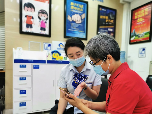 建行成都第六支行，大堂經(jīng)理為客戶介紹手機(jī)銀行&ldquo;大字&rdquo;模式